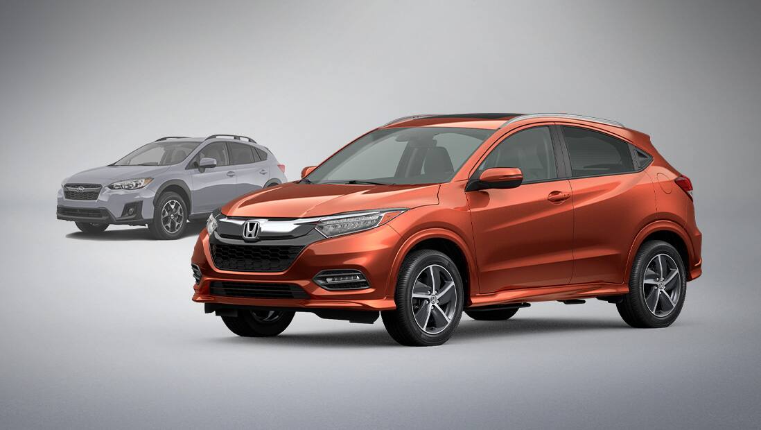 Front passenger-side view of the 2020 Honda HR-V in Crystal Black Pearl parked in front of a competitor's vehicle.