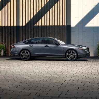 Profile view of 2026 Honda Accord parked against the rooftop structure of the parking garage.