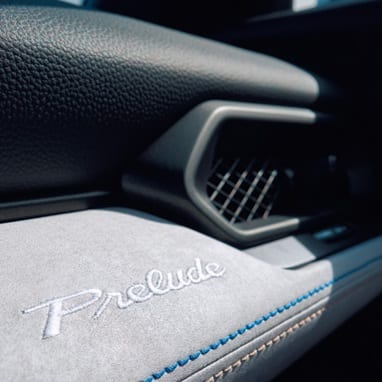 2027 Honda Prelude Bi-Color Stitching and Embroidered Prelude logo on dashboard detail (exhilarating hybrid coupe).
